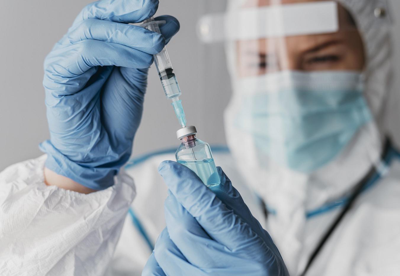 doctor-holding-preparing-vaccine-while-wearing-protective-equipment